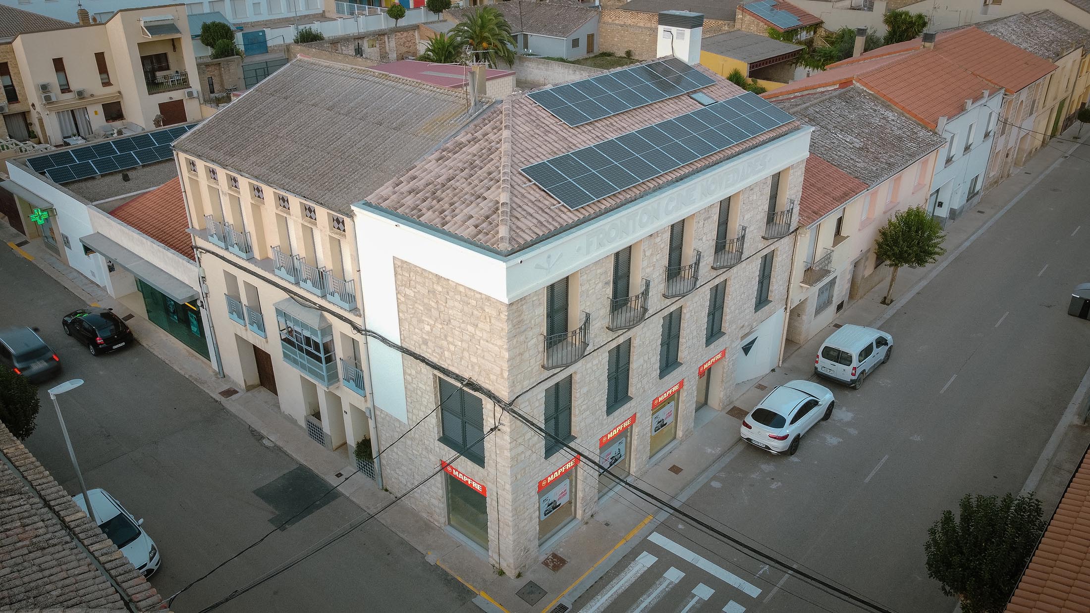 Vista picada de la cubierta de teja y fachada de piedra del edificio rehabilitado